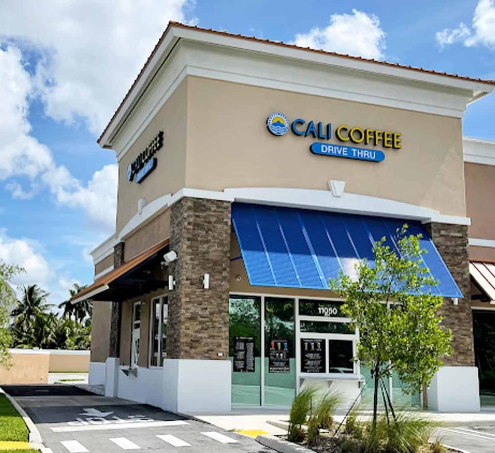 Quiet coffee shop with drive-thru at Cali Coffee, modern facade, inviting outdoor seating, convenient for quick coffee runs.