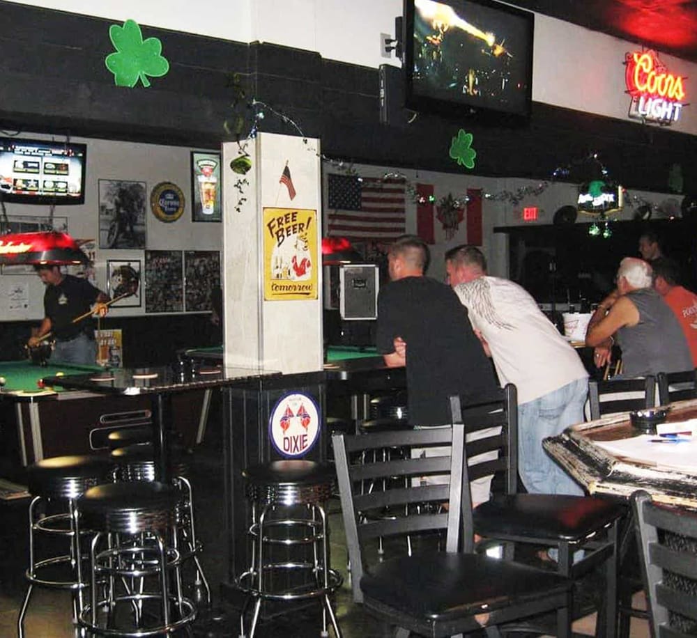 Lively bar scene at QuestForDirections pub with pool tables and patrons enjoying drinks and conversations.