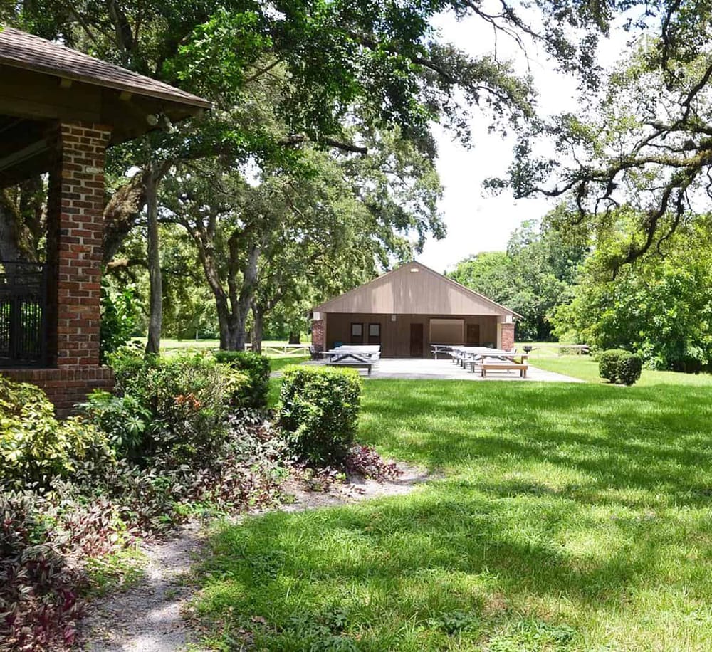 Peaceful outdoor pavilion with picnic tables and lush greenery, perfect for events or gatherings.