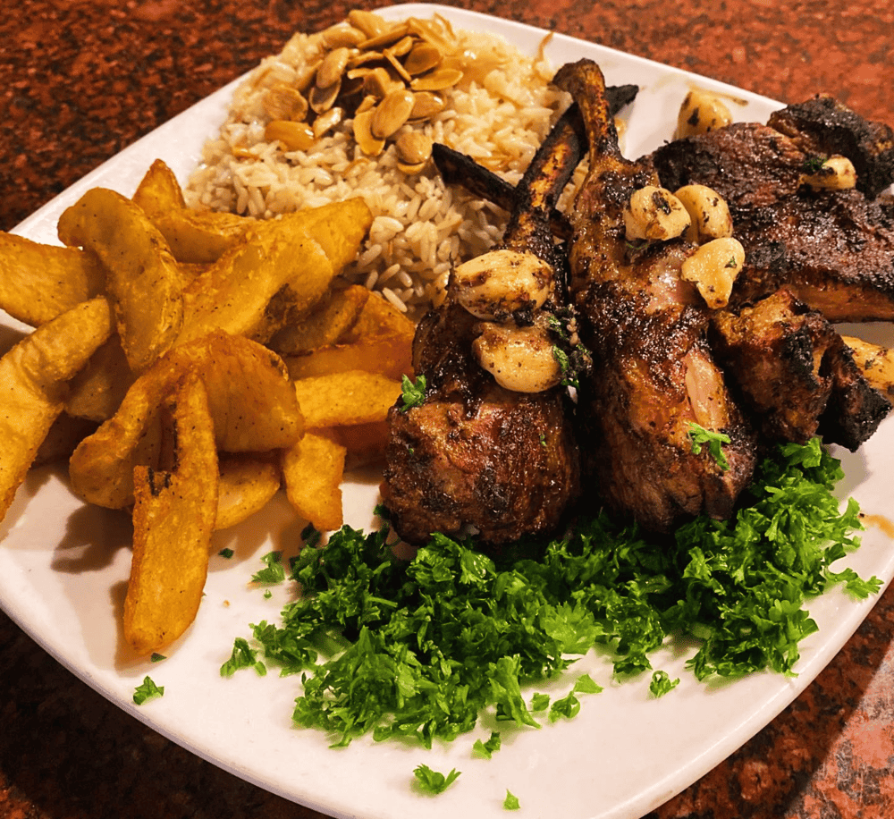 1. Juicy grilled lamb chops with garlic mushrooms, rice, and crispy potato wedges.