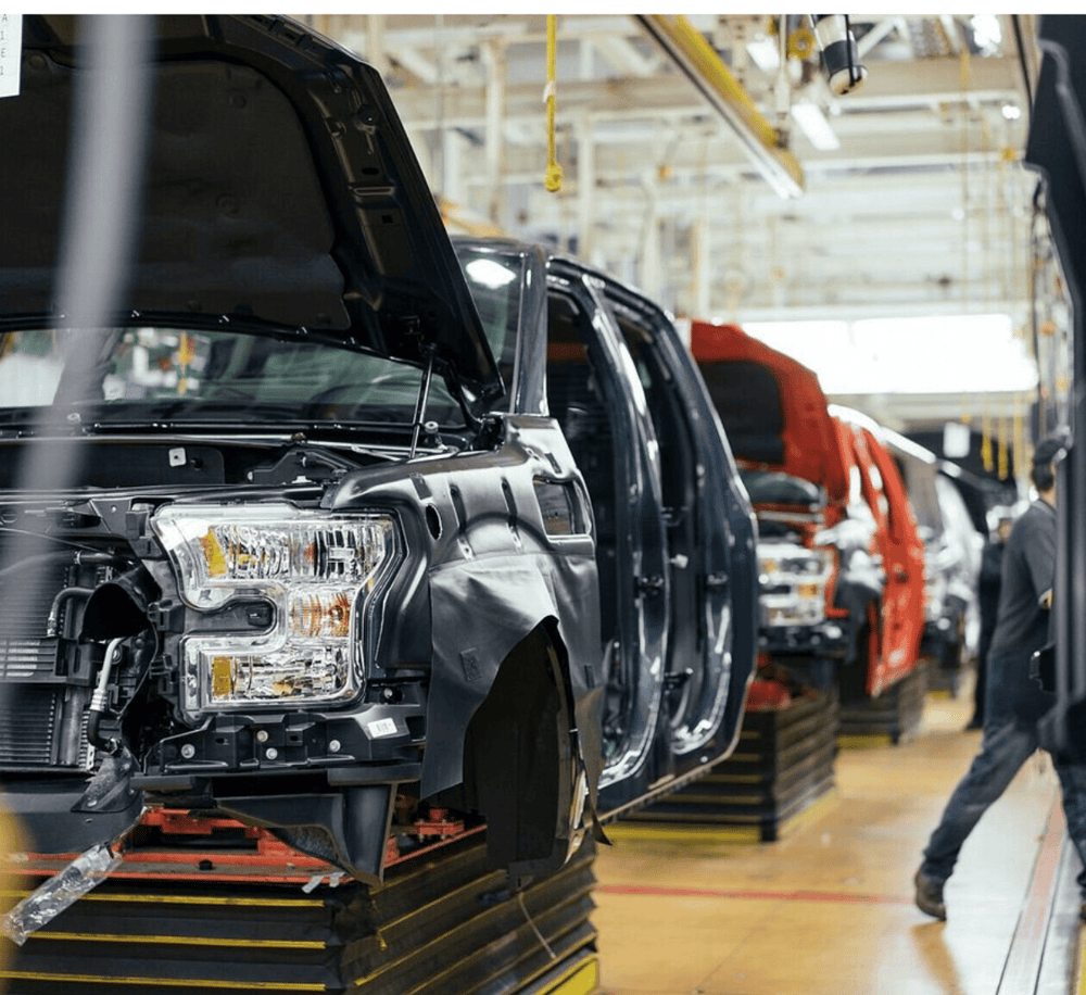 Auto manufacturing factory with assembly line of vehicles for sale, parts, and production.