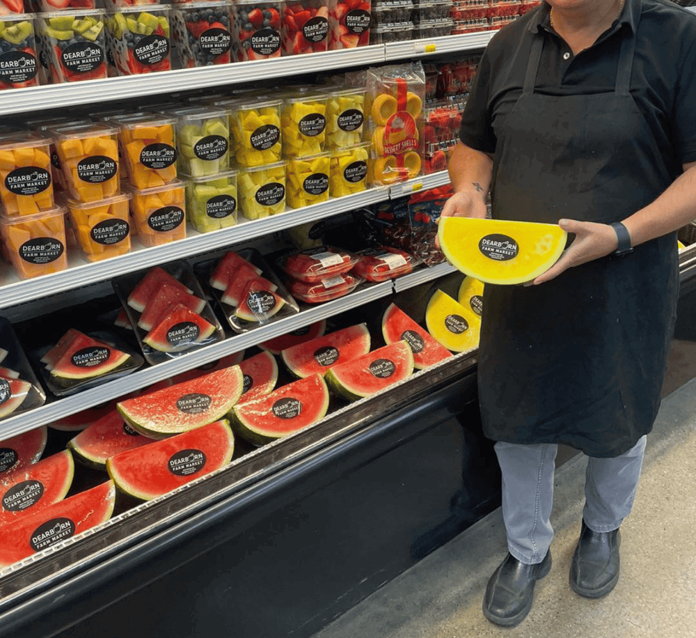 Watermelon and fruit slices in grocery store produce section for healthy eating; branded with Quest for Directions.