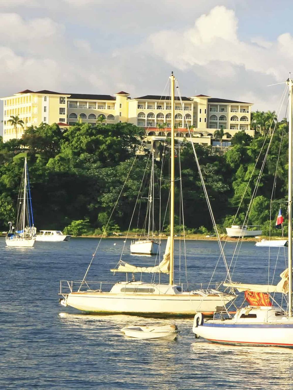 Luxurious waterfront resort with sailboats and scenic ocean view in the Caribbean.