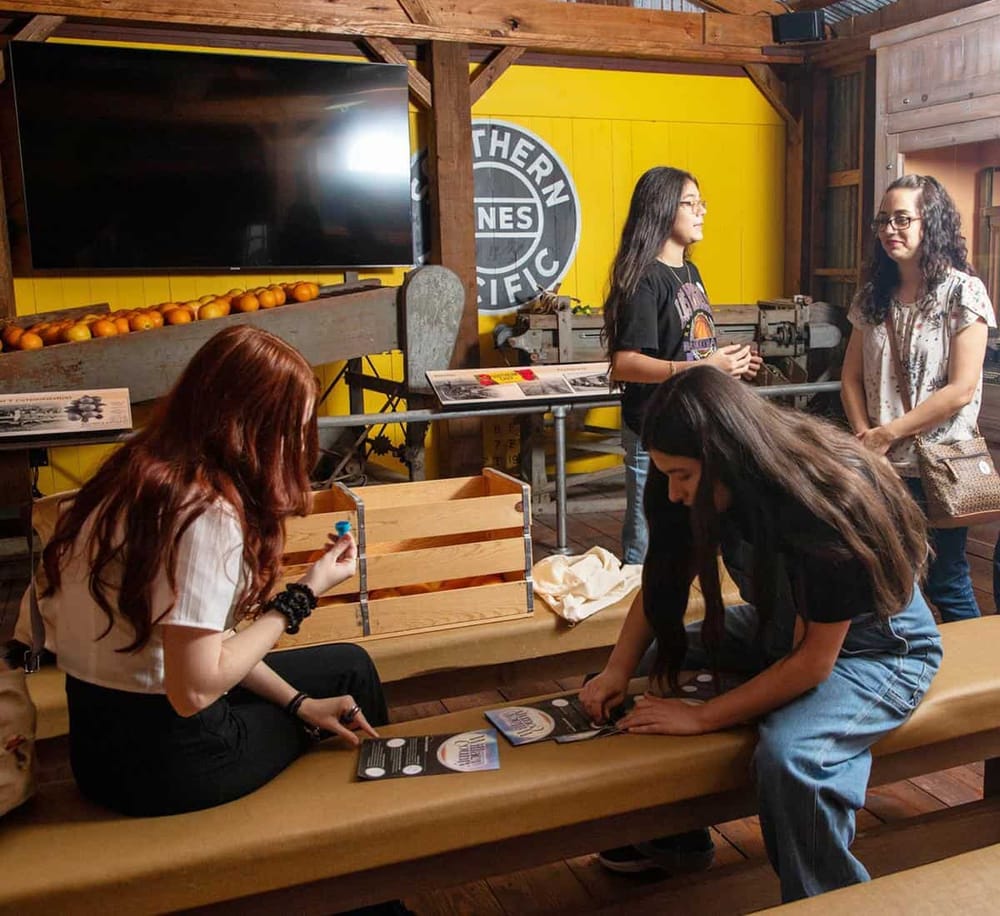 Young women exploring interactive exhibits at Quest for Directions Museum, engaging in educational activities.
