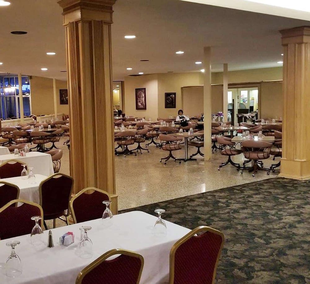Bright hotel restaurant with elegant tables and chairs, perfect for dining and events, featuring warm lighting and spacious seating.