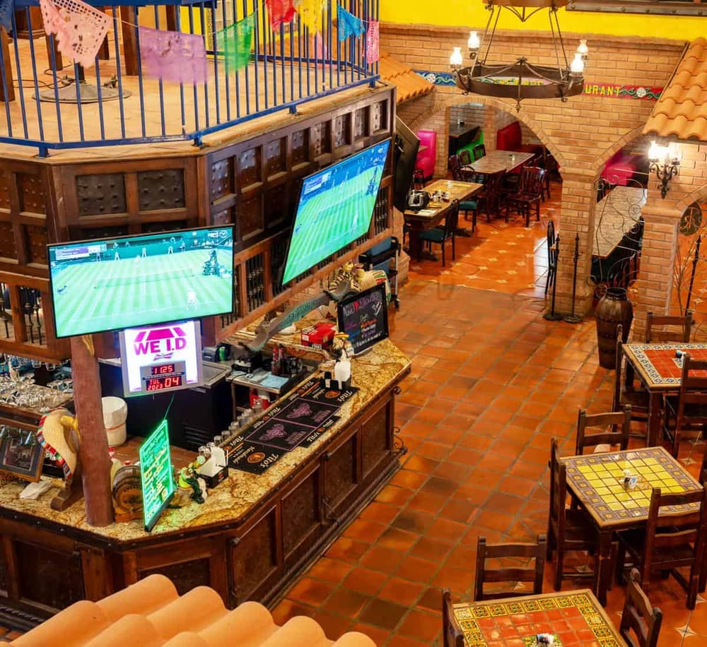 Cozy Mexican restaurant with multiple TV screens for sports viewing and vibrant decor.