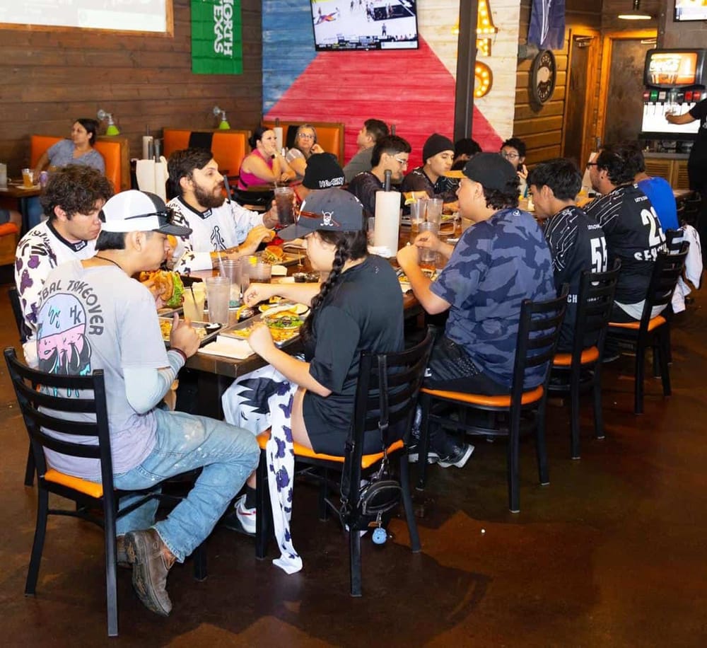 Young people dining together at a lively restaurant matching the QuestForDirections theme.