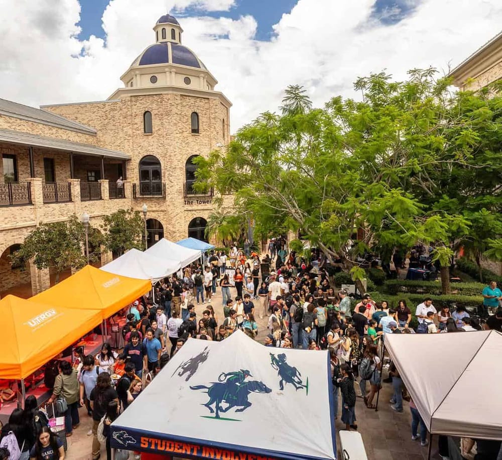 Outdoor shopping event at QuestForDirections with crowds, tents, and a historic building backdrop.