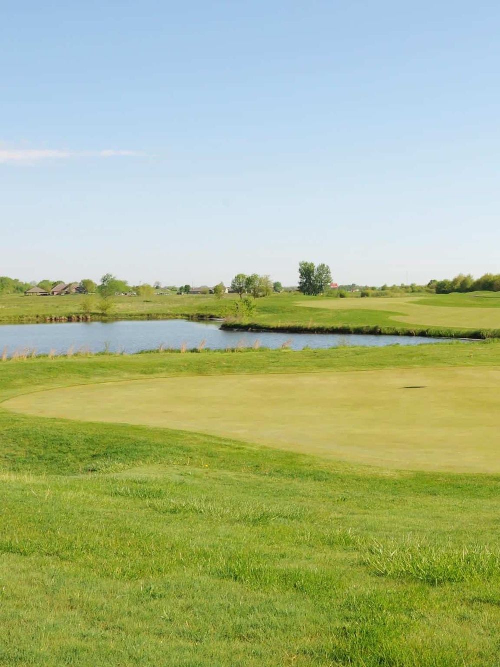 Scenic golf course with water hazard and lush green fairways, ideal for golf enthusiasts.