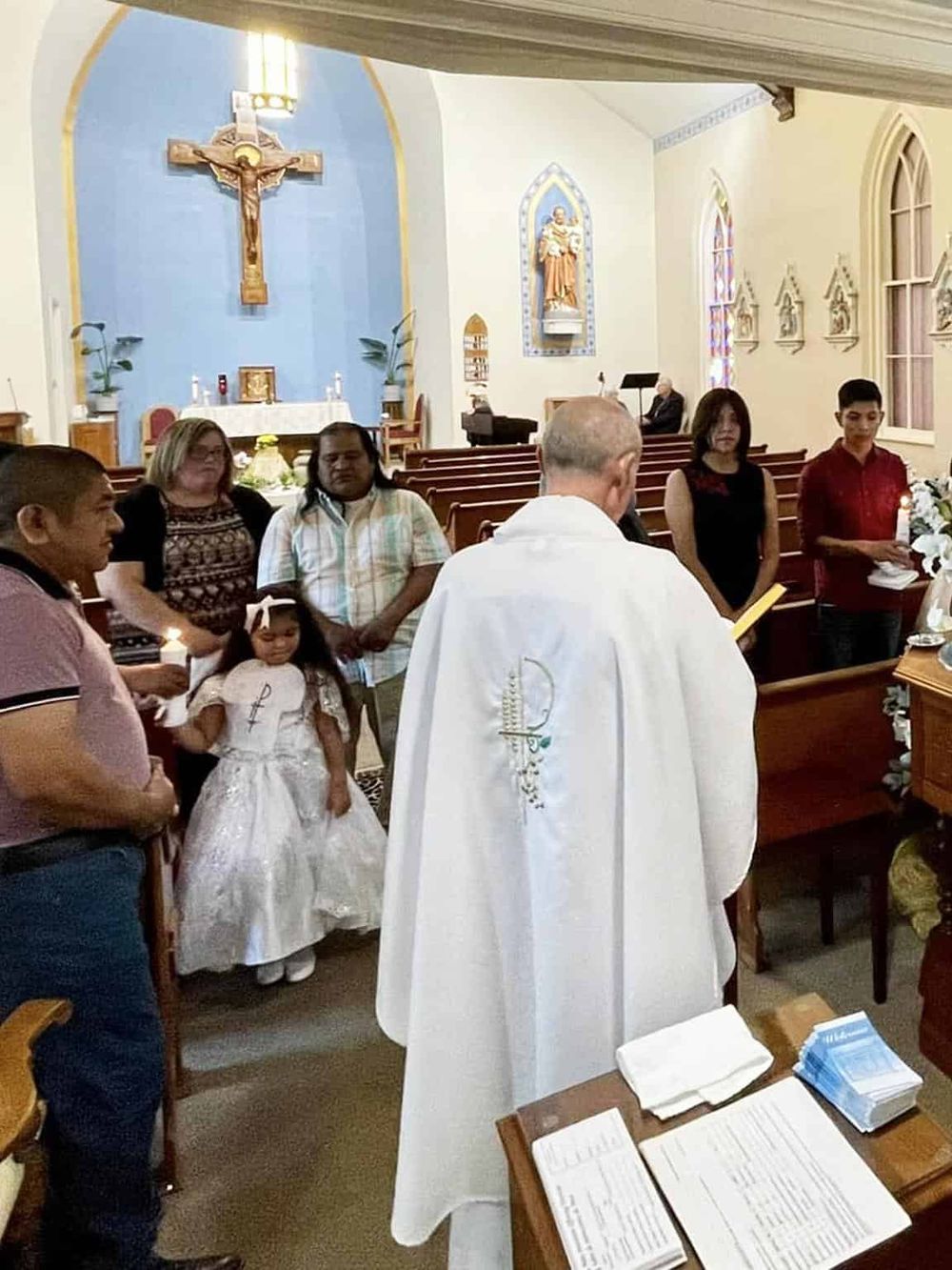 Prayer gathering inside a church with clergy and guests during a religious ceremony.