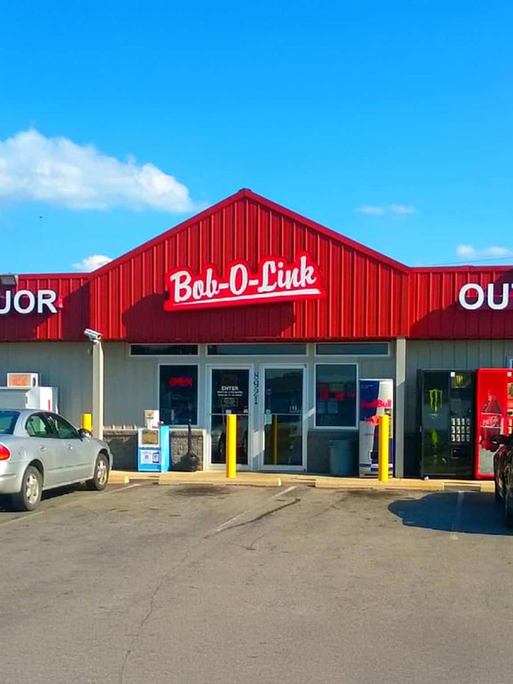 Convenience store with red signage, located at QuestForDirections, offering snacks, drinks, and everyday essentials.