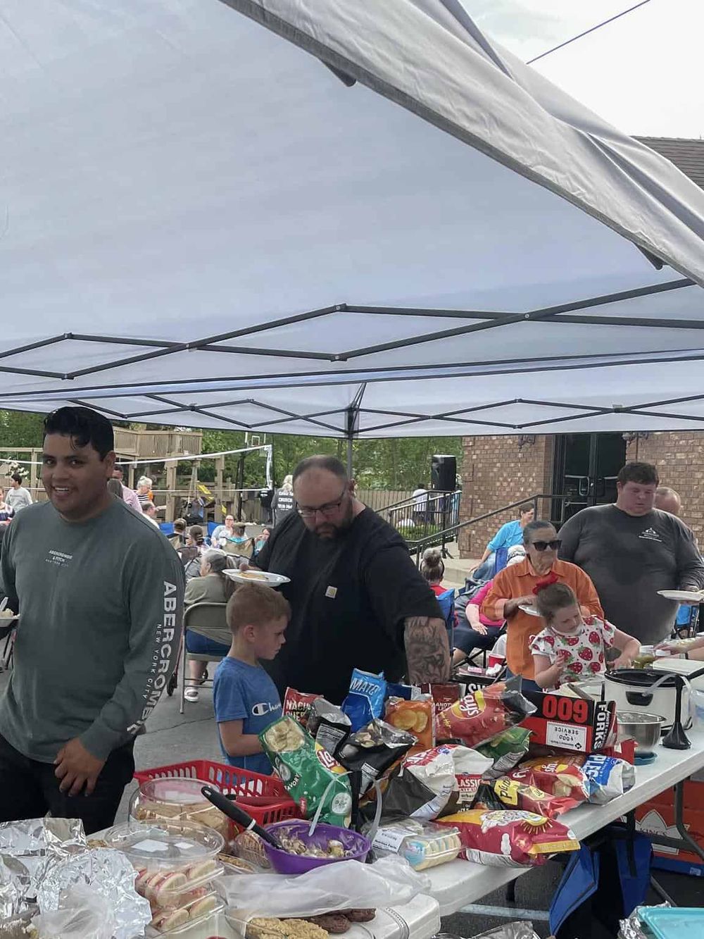 Outdoor community event with food trucks and picnic area.