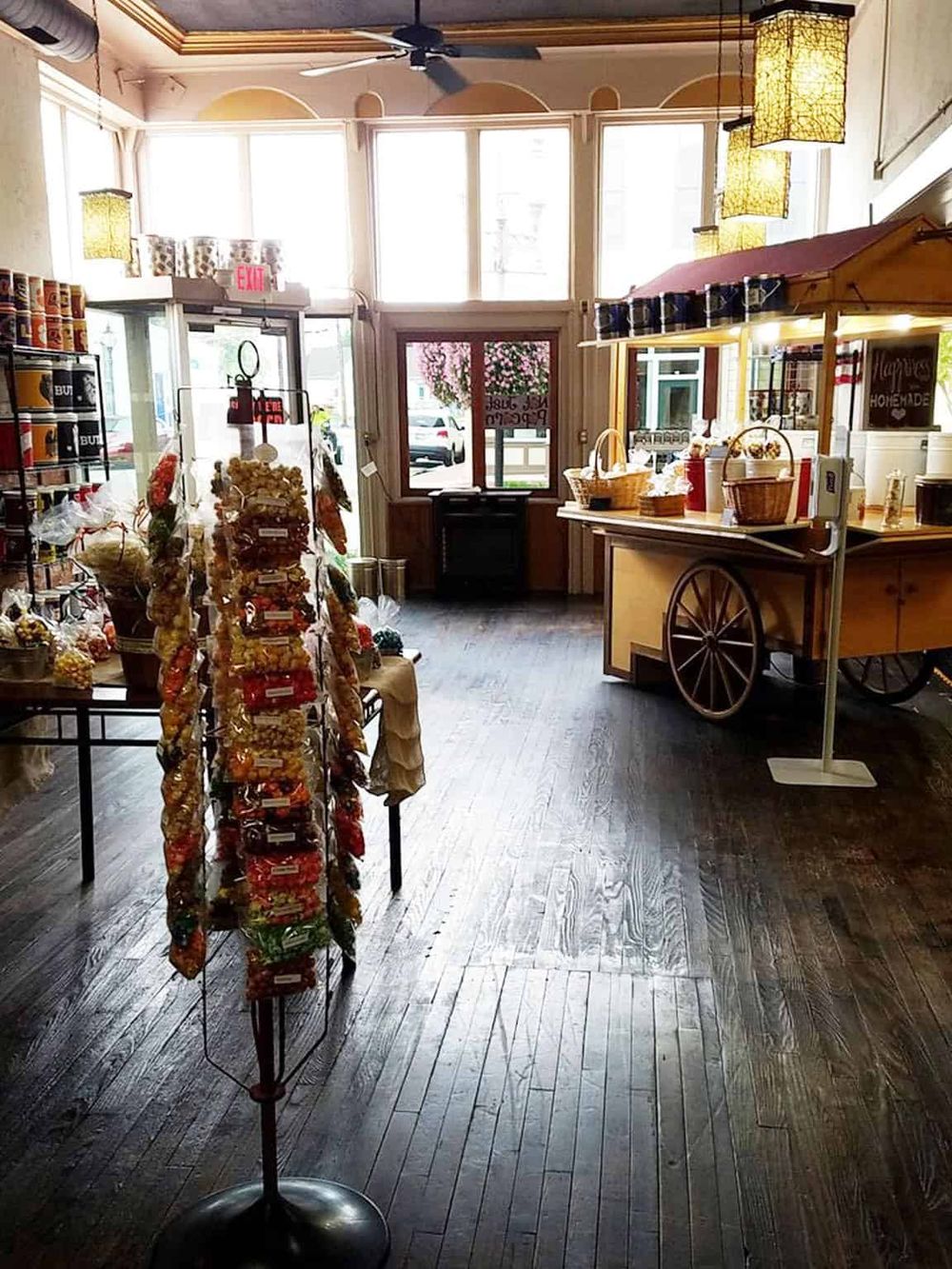 Colorful candy display inside cozy grocery store with wooden floors and large front windows.