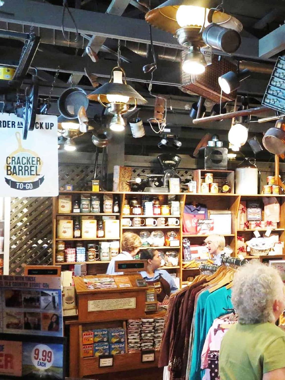 Vintage-style hardware store interior with shelves of grocery items and customers shopping.