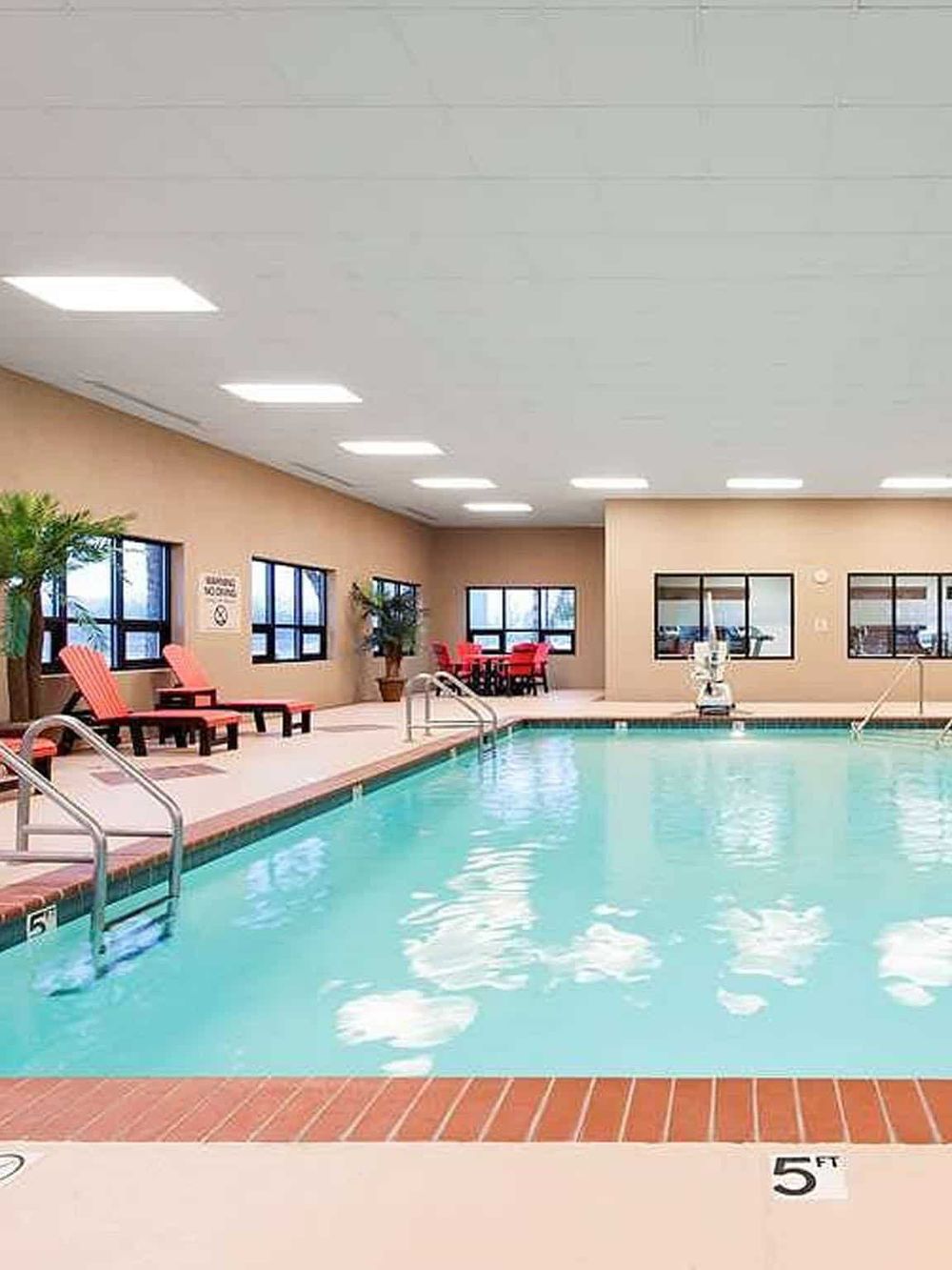 Indoor hotel pool at QuestForDirections, relaxing and inviting with comfortable seating and bright lighting.