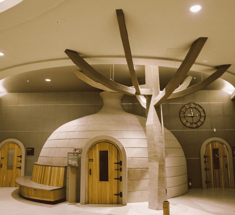 Cozy igloo-shaped relaxation space with wooden doors and a unique tree-shaped ceiling design.