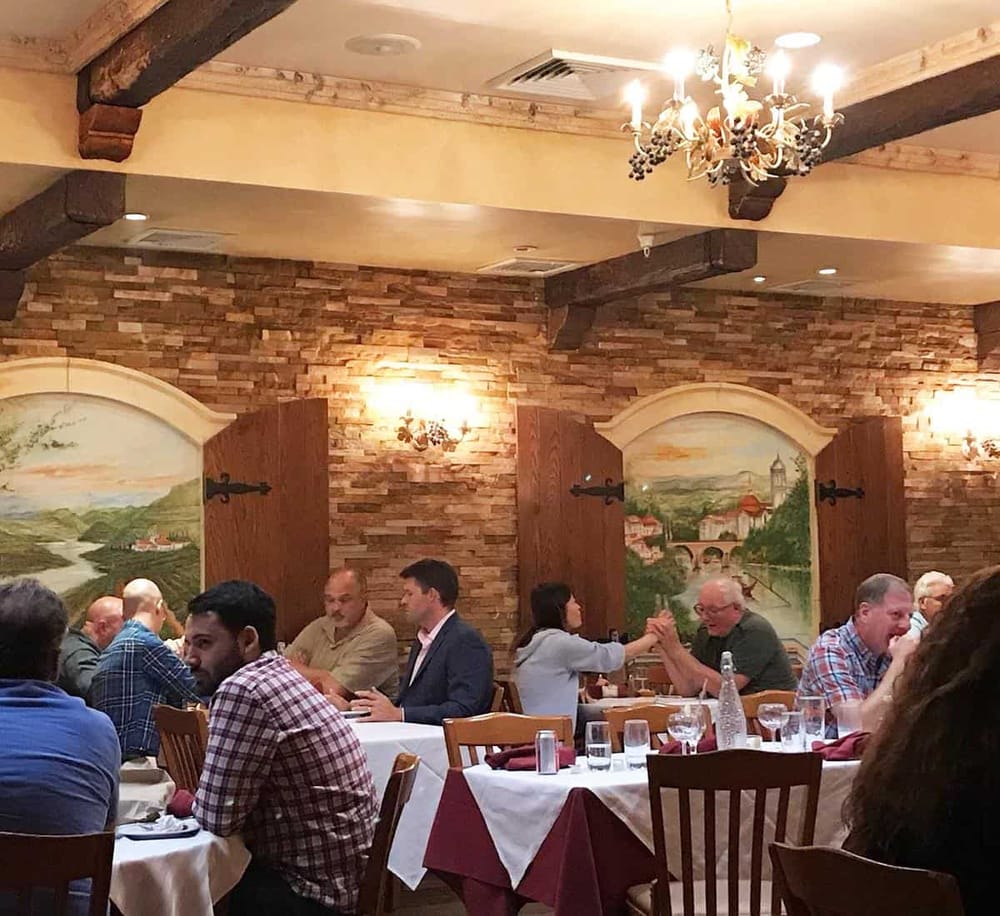 Elegant restaurant interior with rustic brick walls and mural art, perfect for dining and social events.