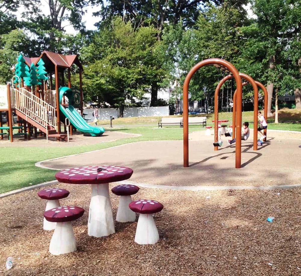 Colorful playground with slides, swings, and seating area for kids at QuestForDirections park.