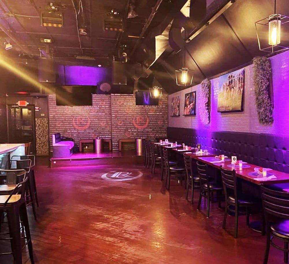 Cozy upscale restaurant interior with modern lighting, artwork, and purple accents, ideal for dining and social gatherings.