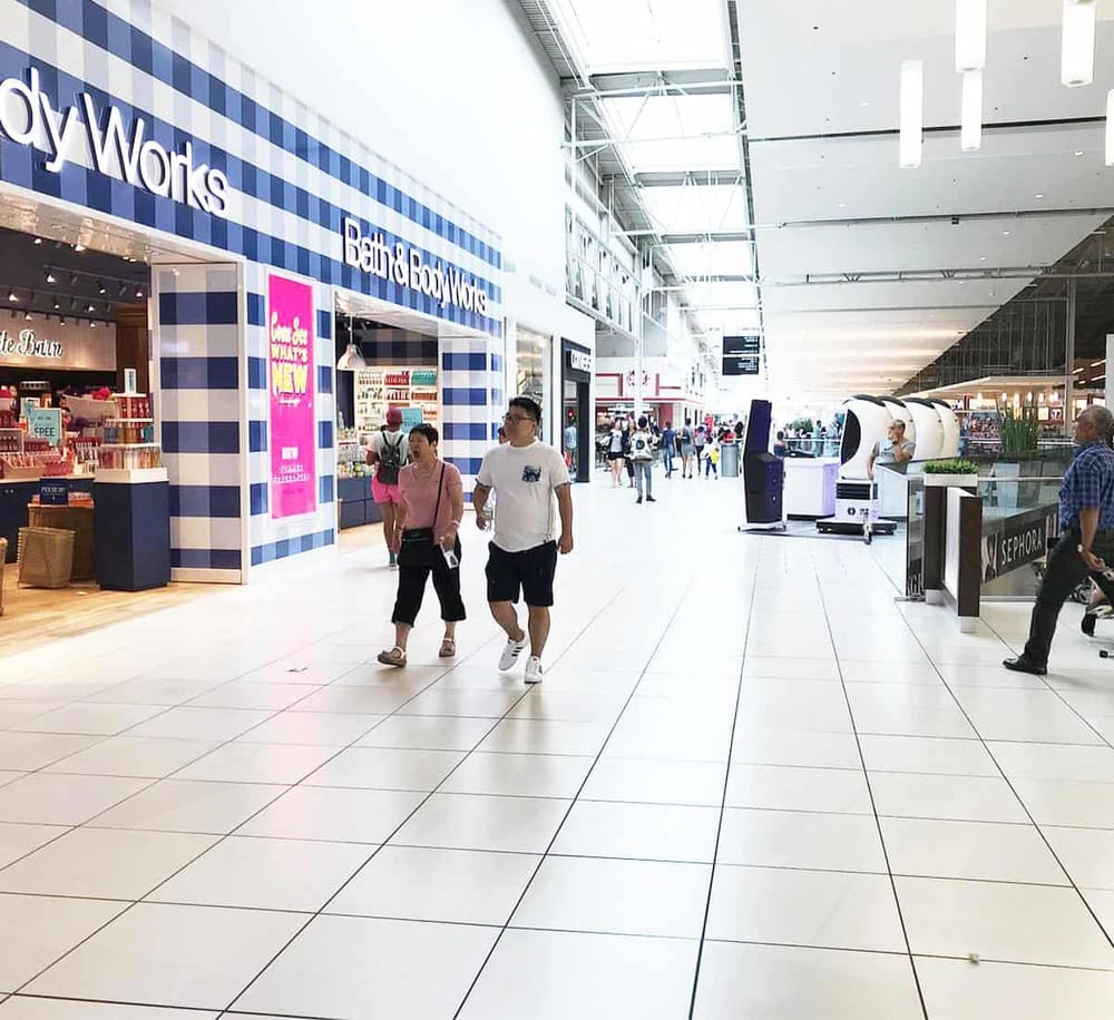 Bright indoor shopping mall with retail stores and shoppers at QuestForDirections.