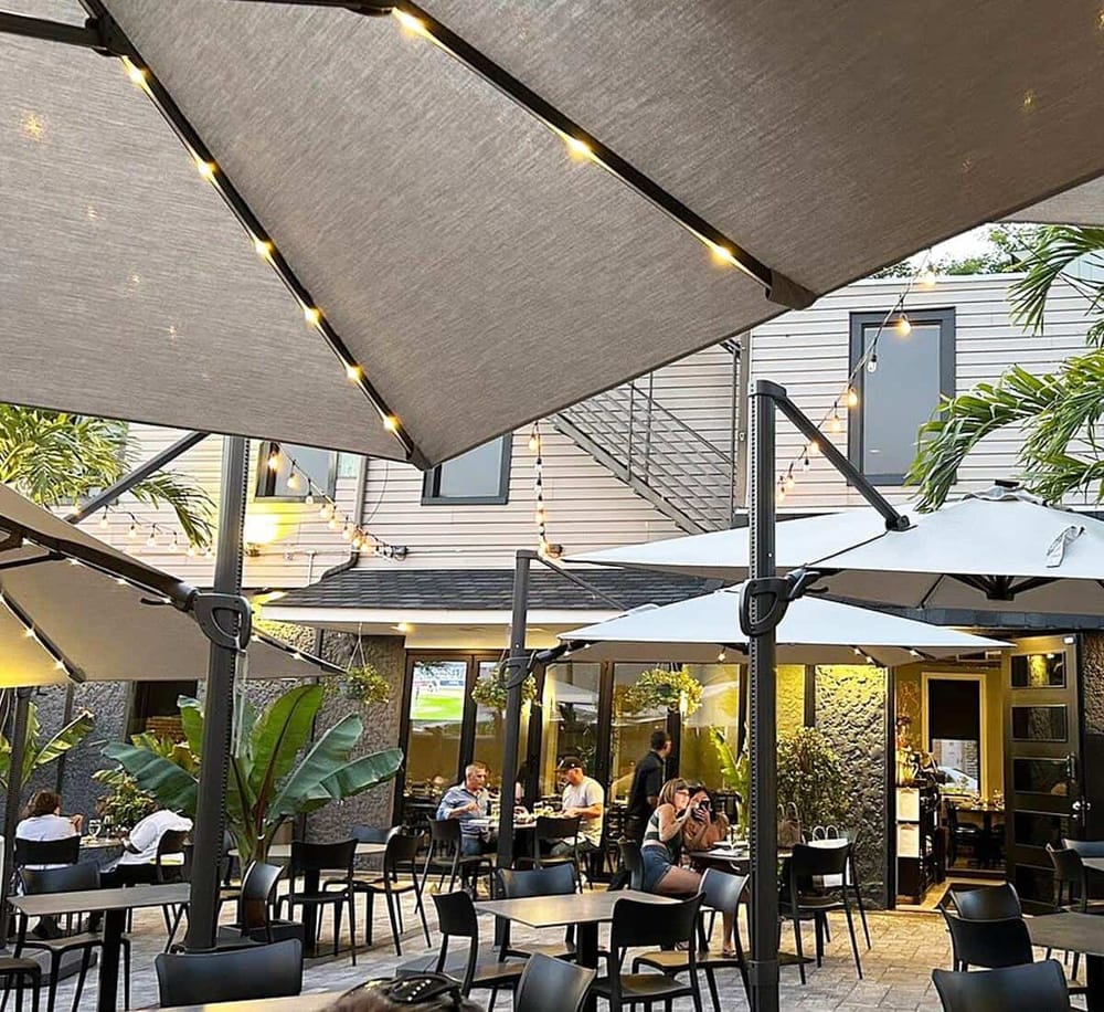 1. Outdoor dining area with umbrellas and string lights at QuestForDirections restaurant.