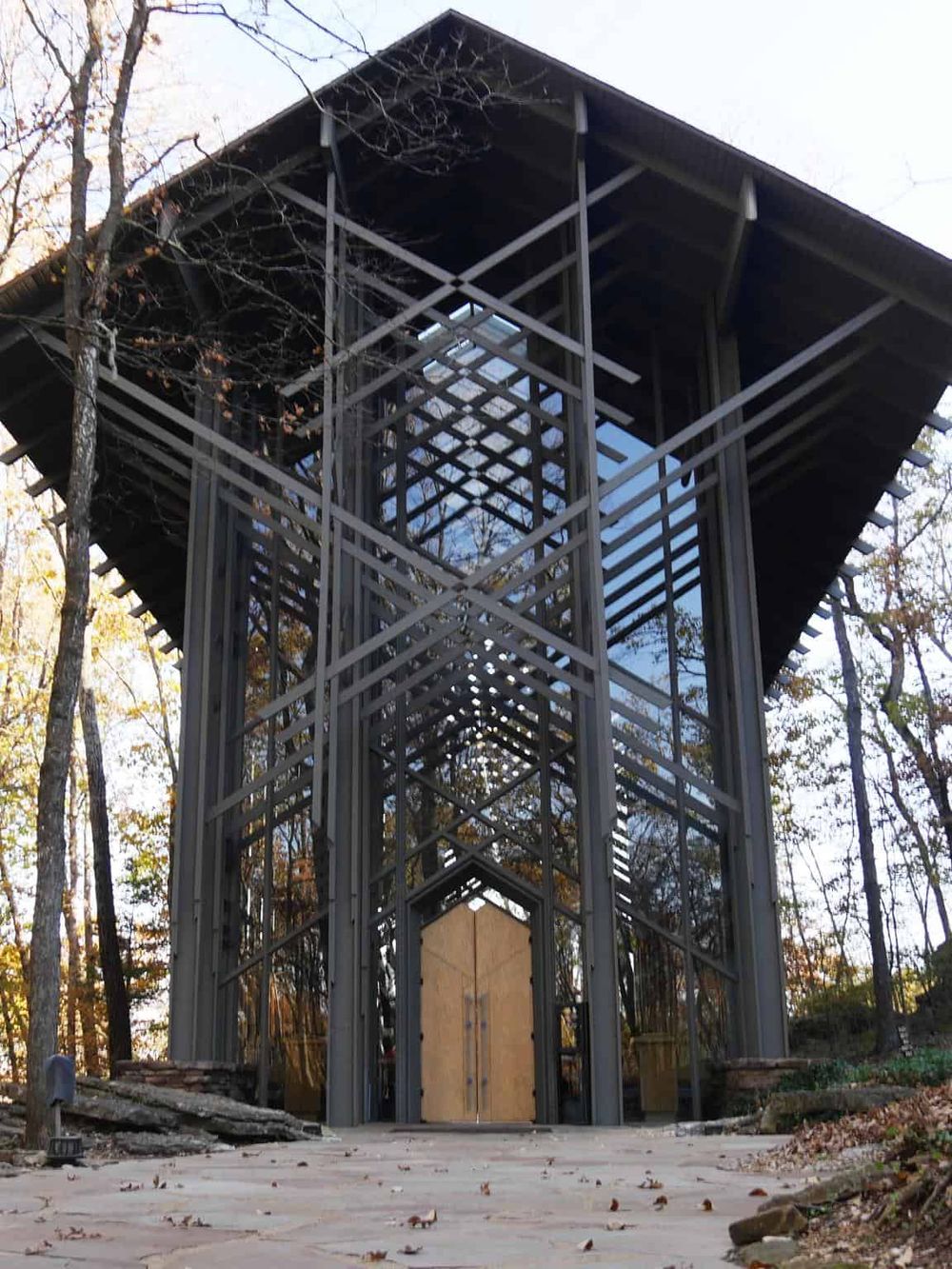 Modern steel observation tower in a wooded park setting.