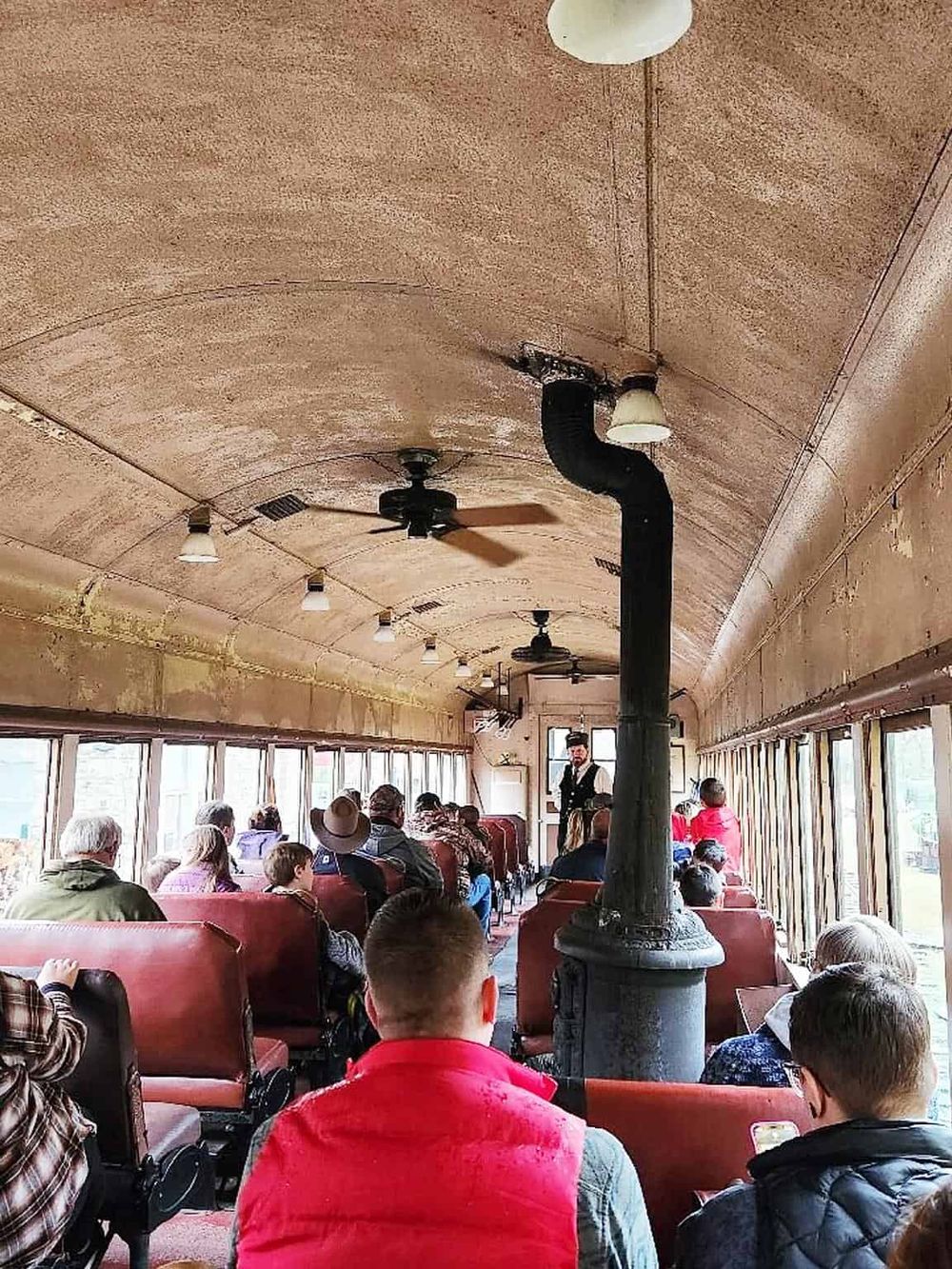 Vintage streetcar filled with diverse passengers on a guided city tour.
