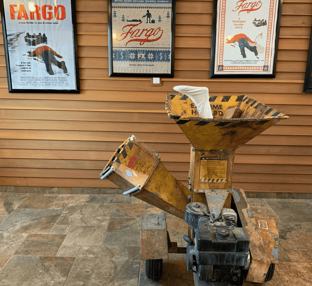 Tissue box holder built from construction tool, displayed indoors with framed Fargo posters in background.