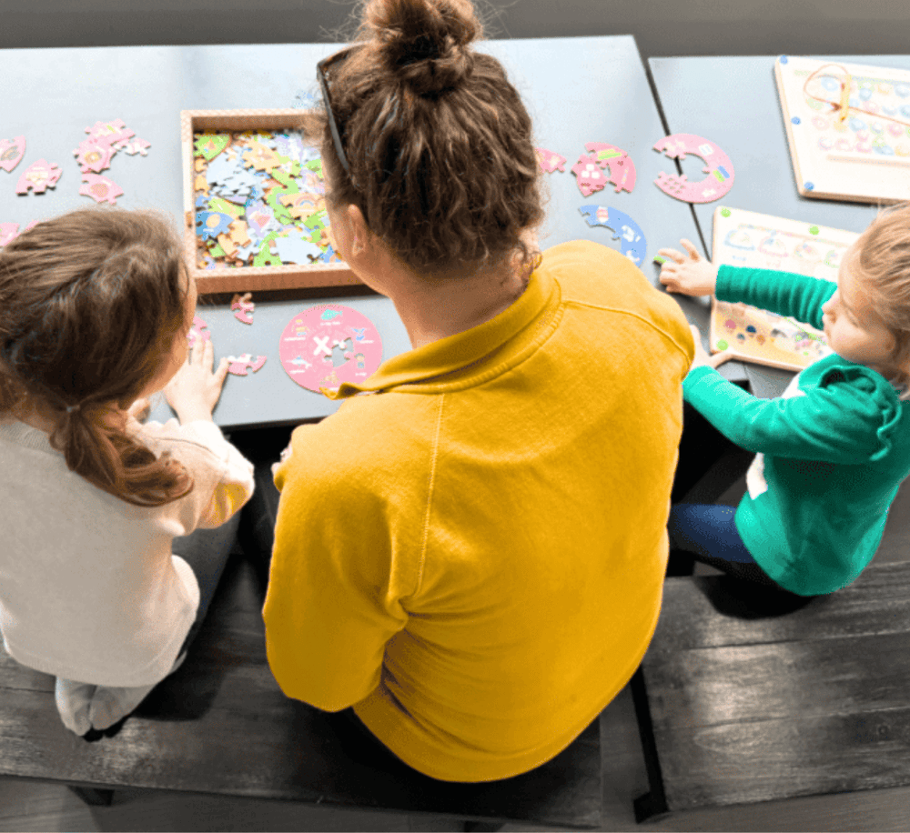 Puzzle activity for children with a caregiver, promoting cognitive development and teamwork.