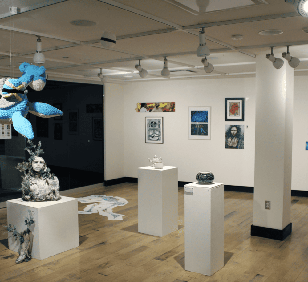 Colorful art gallery display featuring sculptures, paintings, and creative installations at QuestForDirections.