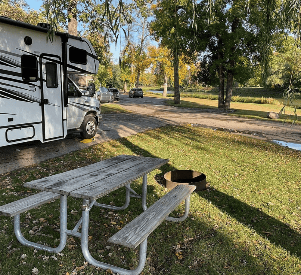 RV parking area at QuestForDirections outdoor location with picnic table and scenic park views.