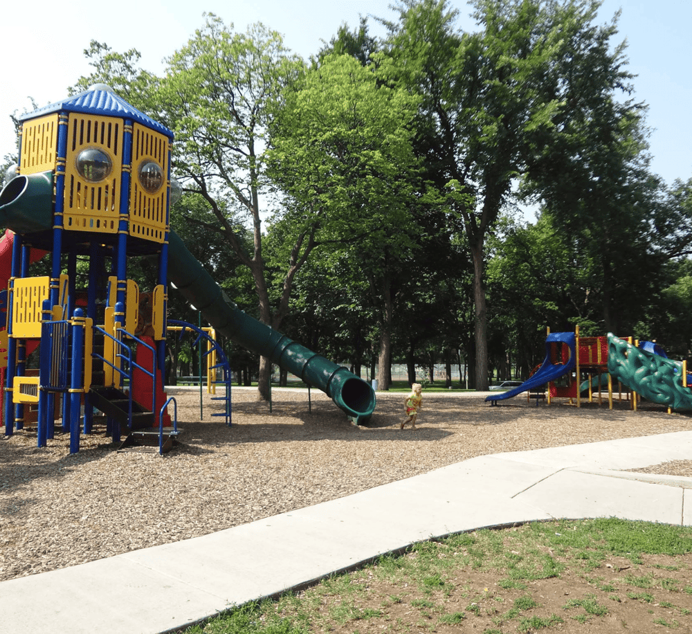 Colorful playground equipment for kids at a park with trees in background, perfect for family outings.