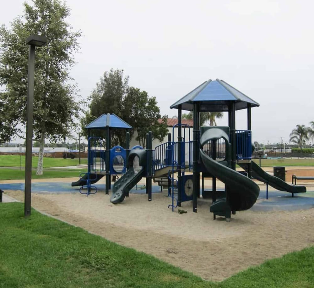 Colorful playground structure at outdoor park with slides and tunnels.