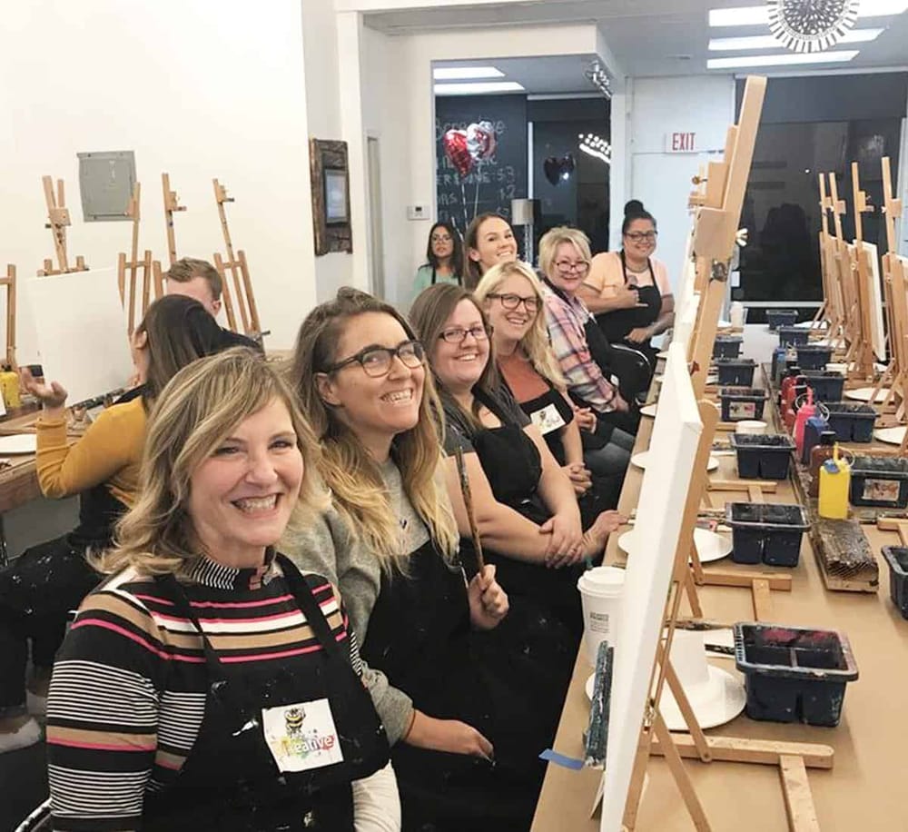 Creative team building painting class at QuestForDirections art workshop.