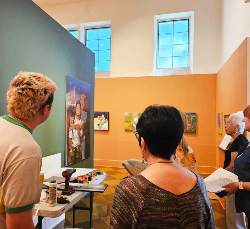 Colorful art gallery featuring visitors exploring artwork and engaging with the exhibit, showcasing art appreciation and museum experiences.