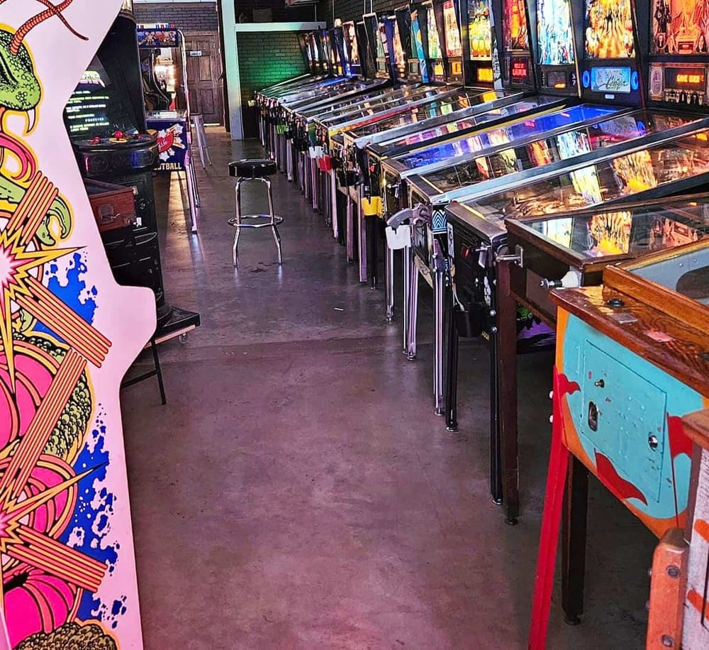 Arcade game room with classic pinball and vintage video machines, perfect for gaming enthusiasts.