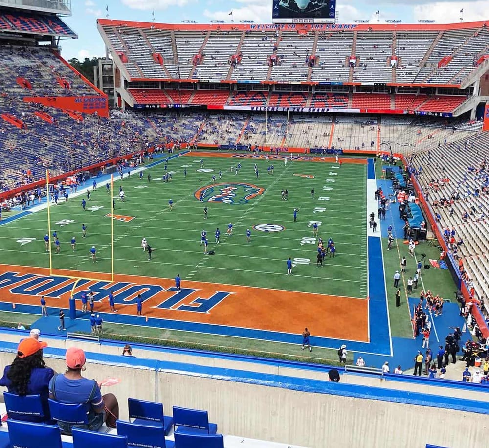 1. Football stadium at the University of Florida with players warming up on the field.