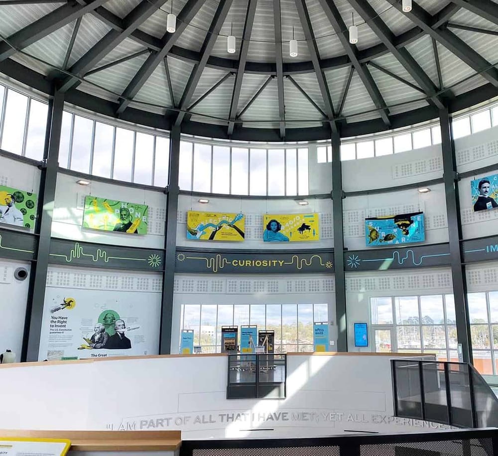 Bright, modern museum interior showcasing science and discovery exhibits with a focus on curiosity.