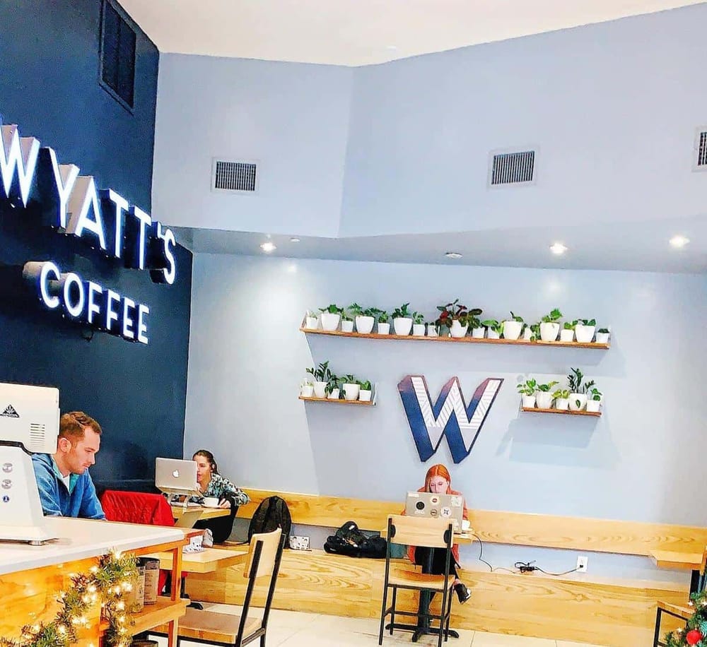 Cozy coffee shop interior with digital workstations and modern decor, perfect for remote work or casual meetings.