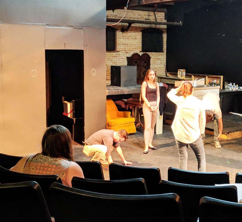 Dynamic theater workshop in an urban performance space with diverse performers and audience engagement.