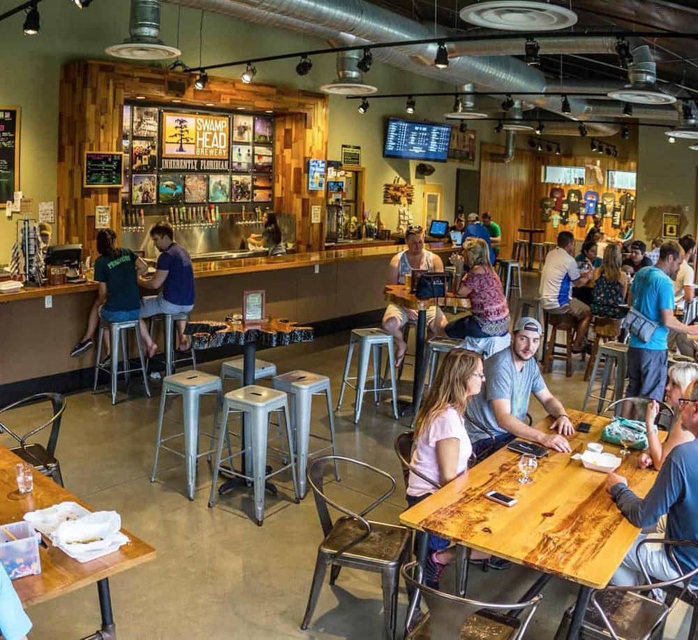 Craft beer bar with seating area and patrons enjoying their drinks at QuestForDirections brewery.