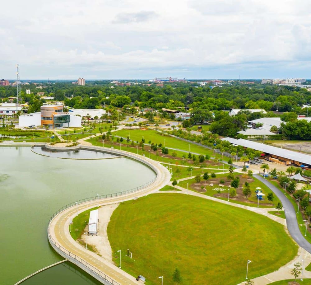 Aerial view of downtown with park, lake, and cityscape, promoting QuestForDirections location-based services.