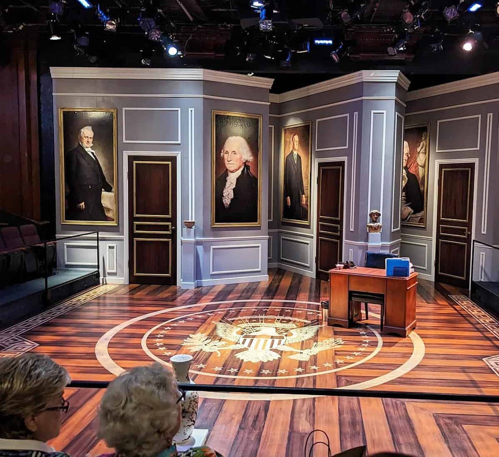 Elegant historical portraits displayed in a museum exhibit with wooden flooring and classic decor.