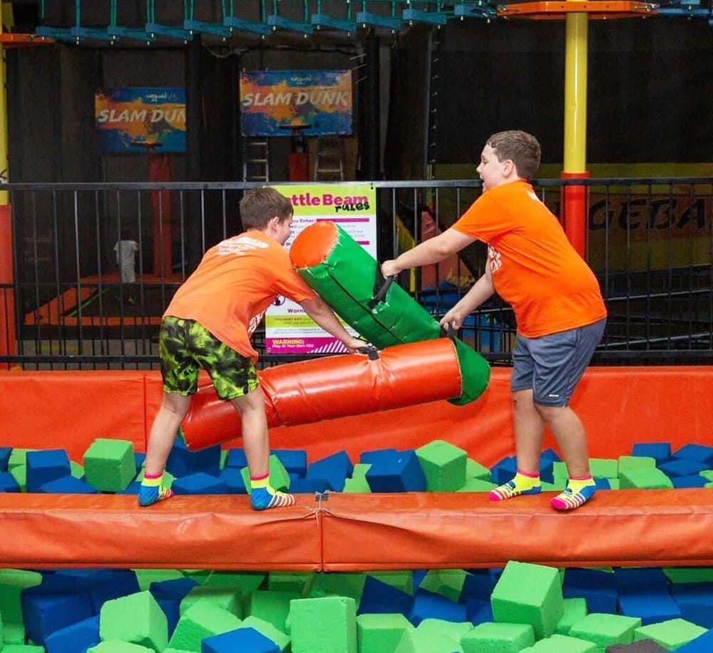 Kids having fun at an indoor trampoline park with foam pit and laser tag arena. Thrilling family entertainment and adventure activities for children.