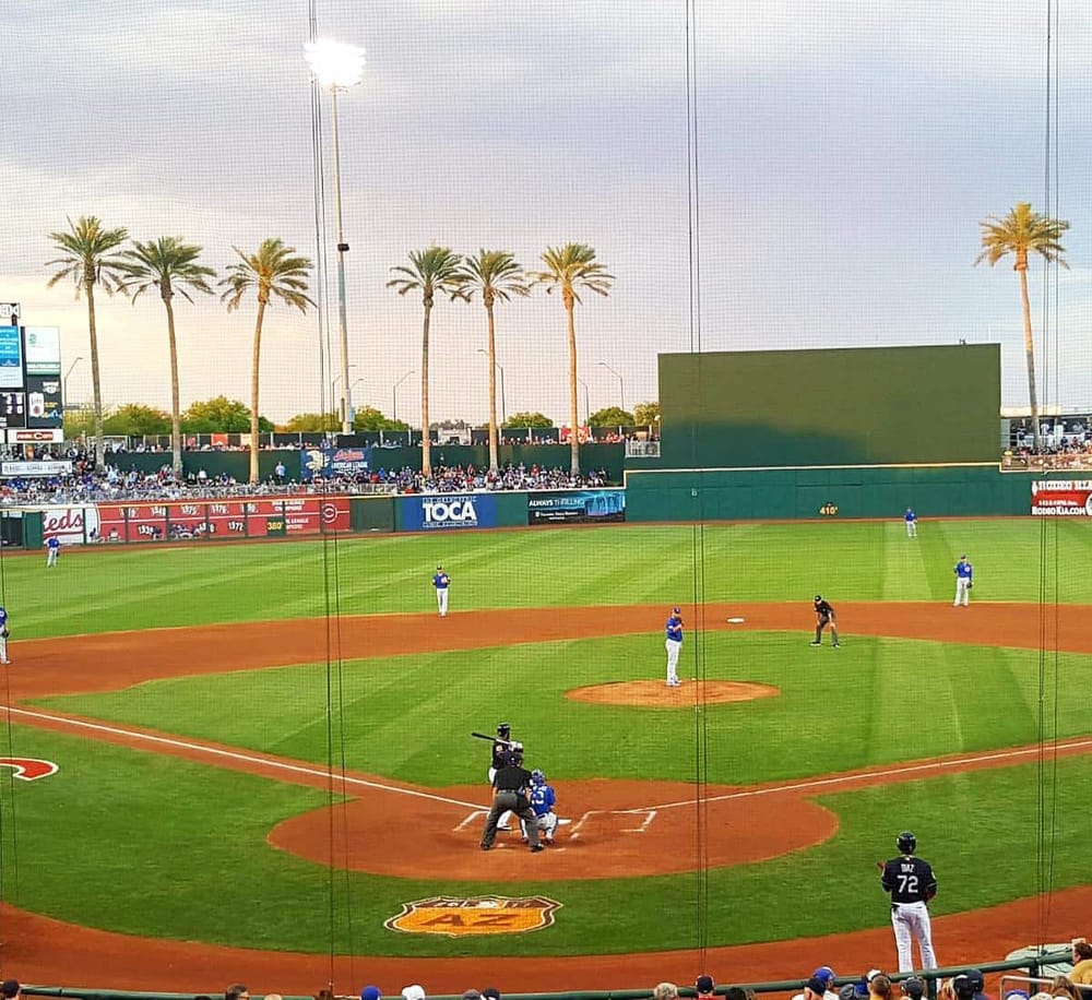 Aerial view of a professional baseball stadium with players on the field and palm trees in the background.