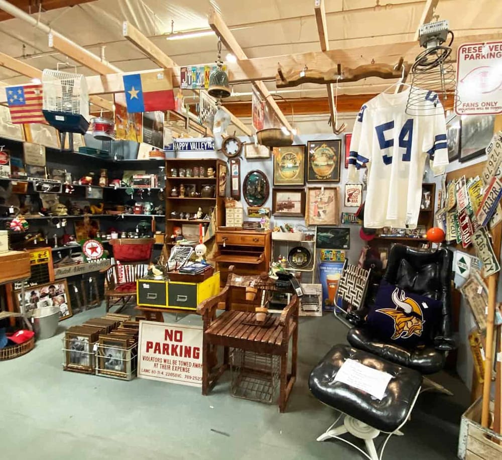 Vintage thrift store with American flags and sports memorabilia, offering unique collectibles and furnishings.