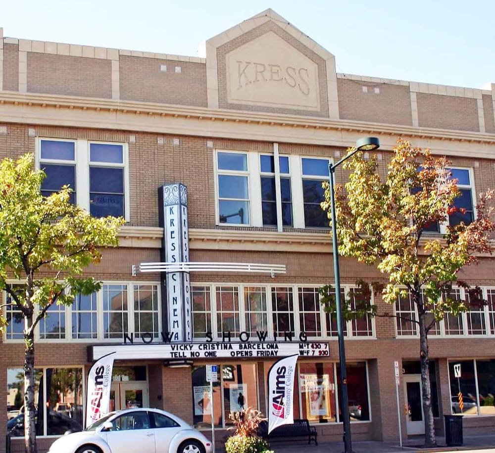 Historic movie theater featuring classic architecture, marquee signage, and vibrant fall trees in an urban setting.