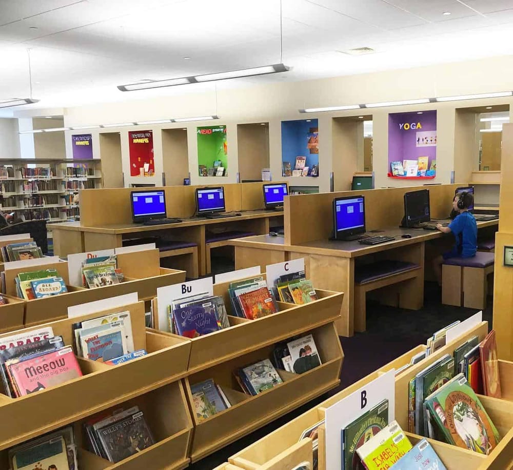 Bright school library with computers and colorful children’s books, dedicated to learning and literacy.