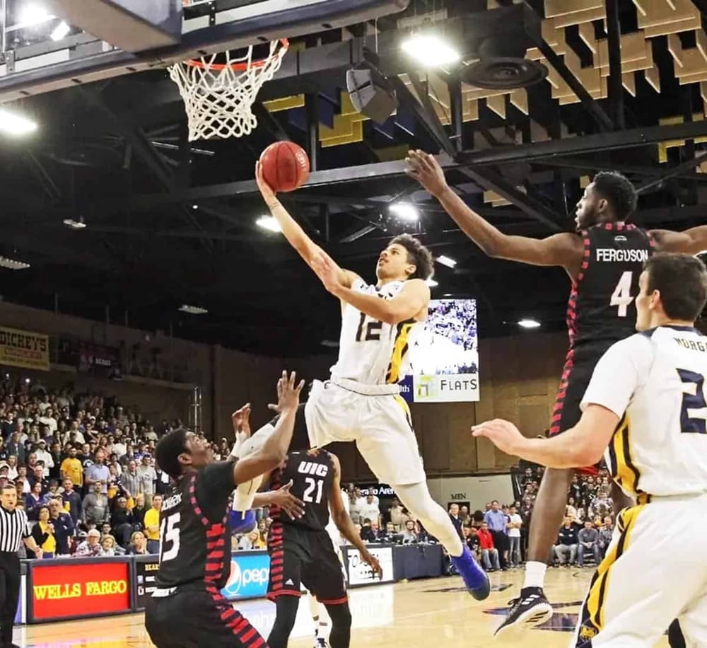 High school basketball game with players in action, competitive match under gym lights.