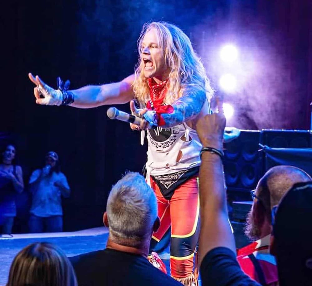 Bold female performer passionately engaging crowd at QuestForDirections event, lively music and vibrant atmosphere.